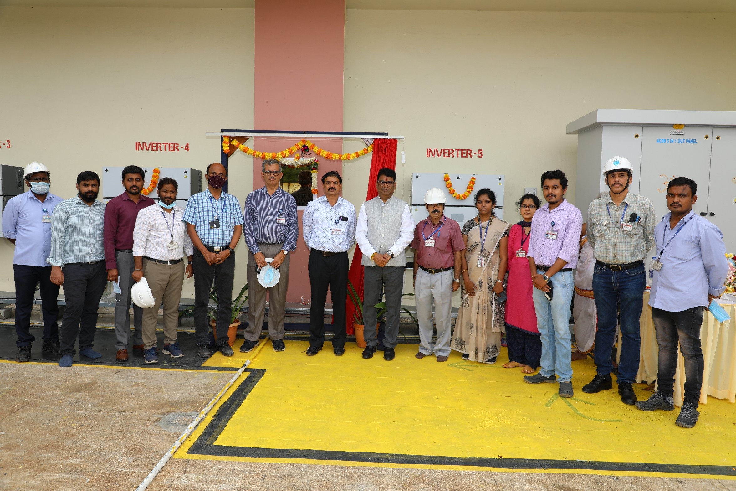 Group picture with CE, NFC. Inverters and panels visible behind.