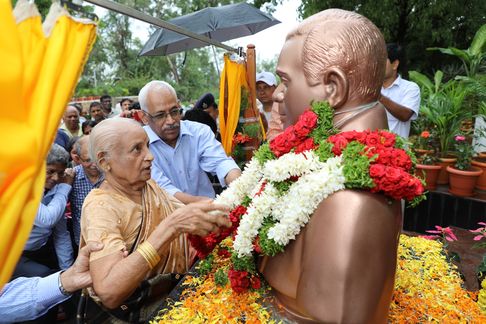 Smt. N. Srimahalakshmi garlanding the bust of Dr. N. Kondal Rao.